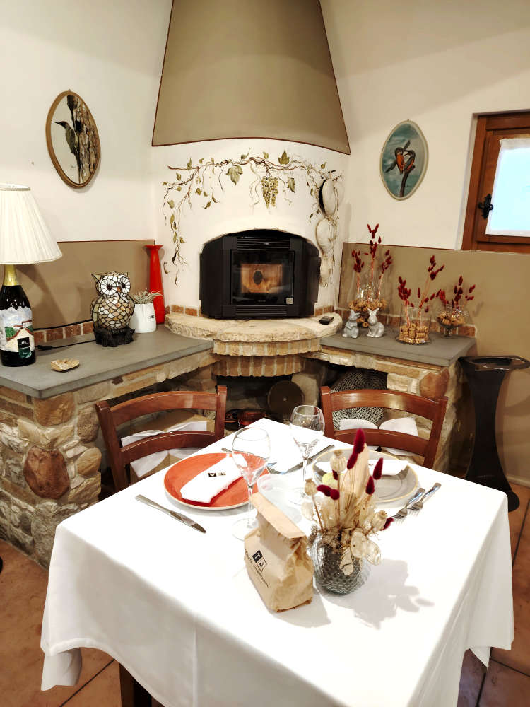 Tavola apparecchiata con camino e decorazioni rustiche Tenuta Ambrosini