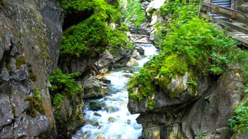 Passerella in legno sospesa sopra le rapide del Rio Racines all'interno della gola di marmo bianco delle Cascate di Stanghe (Gilfenklamm).