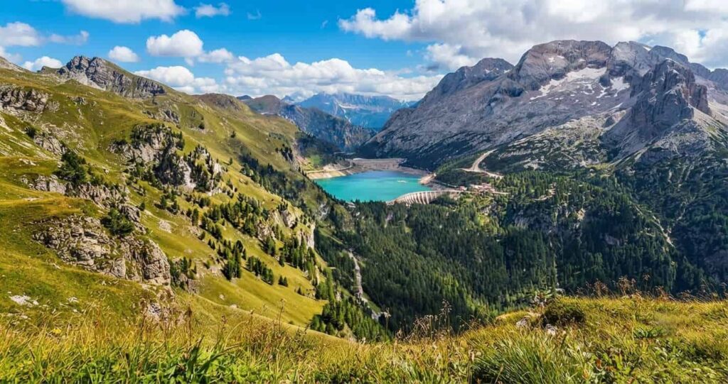 Vista panoramica del Lago di Fedaia e del ghiacciaio della Marmolada lungo l'escursione al Sentiero Viel del Pan in Val di Fassa.